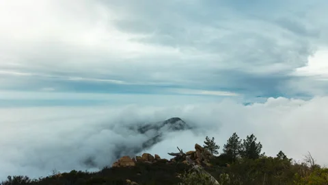 Clouds rolling over mountains turning into fog time lapse 4k 24fps Stock Footage 132874013