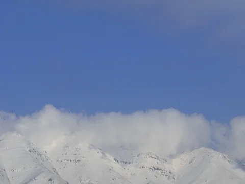 Clouds Rolling over Snow Covered Mountains Stock Footage 73545846