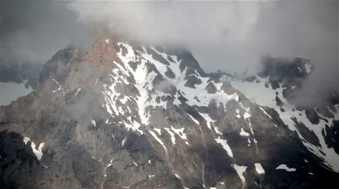 Clouds rolling over snowy high mountain peaks Picos de Europa Asturias Spain  Stock Footage 63631285