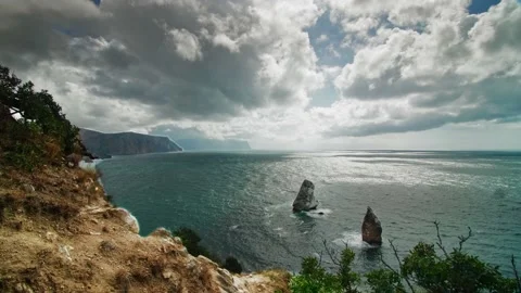 Clouds run across the sky against the background of the sea bay, with a rock Stock Footage 218405409