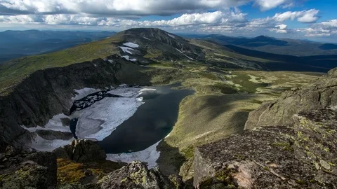 Clouds run on the background of a lake in the mountains time lapse Siberia Stock Footage 93872613