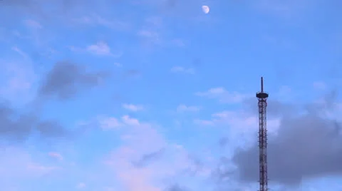 Clouds run in the sky, a teletower, the moon Stock Footage 22775156