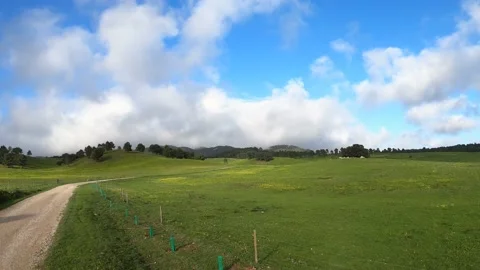 Clouds running over the green field. Timelapse Stock Footage 134836575