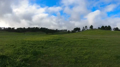 Clouds running over the green field. Timelapse Stock Footage 134836660