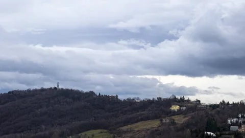 Clouds running over mountain with buildings and wood time lapse Stock Footage 265108098