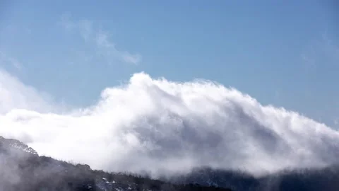 Clouds Rushing Across Mountain Peaks on Sunny Day Stock Footage 137772746