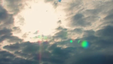 The clouds seem to be breaking as sunflare hits the lens of the camera dancing Stock Footage 93556621