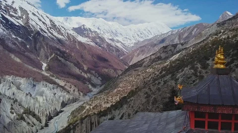 Clouds shadows crawl over snowy mountain slope, Tilicho Peak, red pagoda, Nepal Stock Footage 124679151