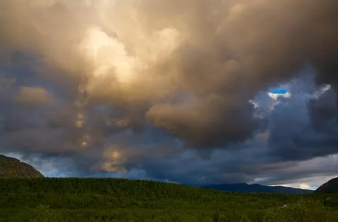 Clouds in the sky above the mountains lit by the sun at sunset. Foto stock