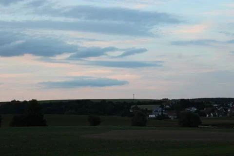 Clouds in the sky after sun set with village in the background Stock Photos