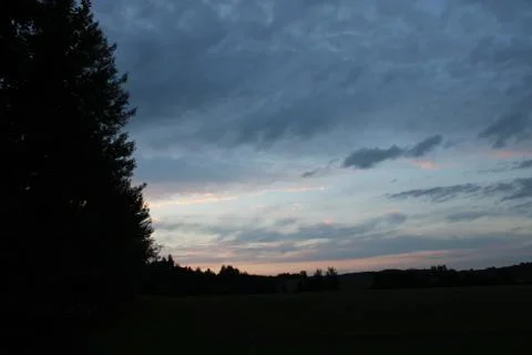Clouds in the sky after sun set with a tree Stock Photos