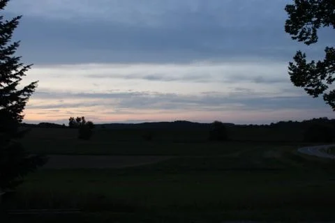 Clouds in the sky after sun set with two trees Stock Photos