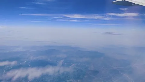 The clouds in the sky and the land below and the wing of the aircraft were photo Stock Footage 157100766