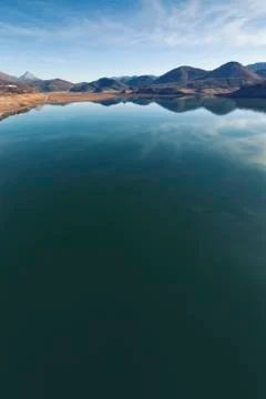 The clouds of the sky are reflected in the water of the Riaño reservoir Stock Photos