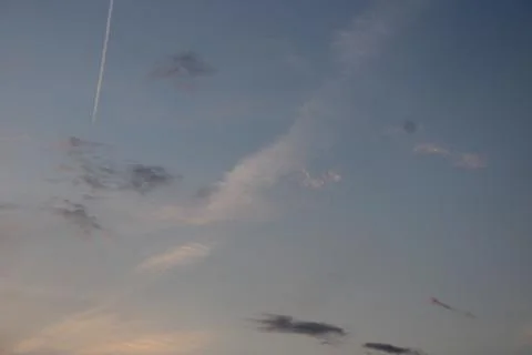Clouds in the sky in the evening with a plane flying above Stock Photos