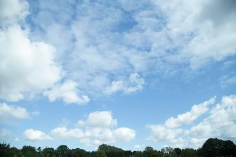 Clouds in the sky with a low tree line Stock Photos