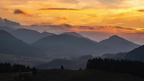 Clouds sky moving fast over forest mountains landscape at golden sunset time Stock Footage 266740555
