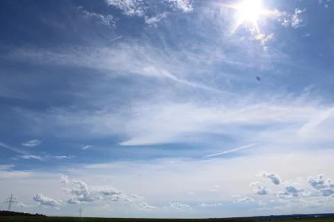 Clouds in the sky over a cornfield with electric posts in the background. Stock Photos