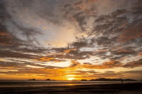 Clouds on the sky reflection of sun in the water and sand on beach Beautif... Фото