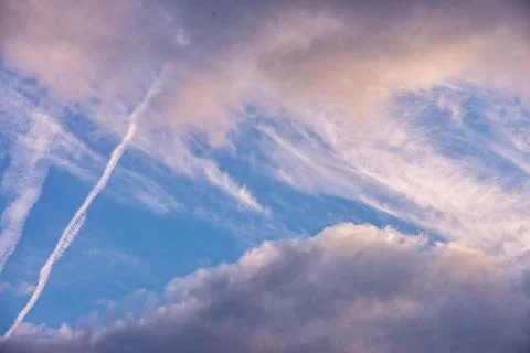 Clouds in the sky with a trace of an airplane Stock Photos