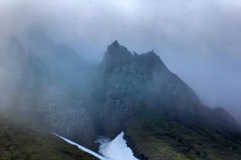 Clouds slide over from glacier and cliff to sea Stock Photos
