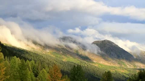 Clouds slowly climbing over mountains in the fall. Stock Footage 10748760
