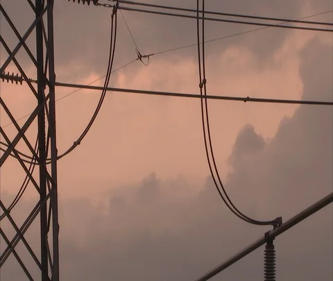 Clouds slowly drift past CU of electrical power plant lines Stock Footage 86694754