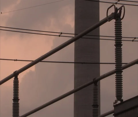 Clouds slowly drift past CU of electrical tower and lines Stock Footage 86694775