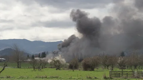 Clouds of smoke from a distant fire across a field 動画素材 59534591