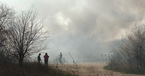 Clouds smoke fire in city park on blue sky, teenagers in park are looking smoke Stock Footage 127189518