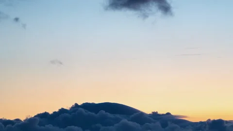 Clouds smoothly flowing over mountain during sunset Stock Footage 277796178