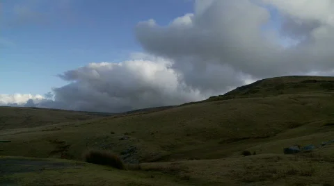 Clouds speed across rolling, rugged hills and mountains Stock Footage 507624