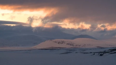Clouds at sunset fly over the snowy hills Stockbeeldmateriaal 118907290