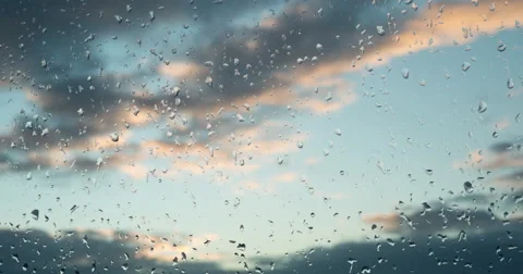 Clouds at sunset move across the sky. Raindrops on a window. After the rain.  Video stock 60259912