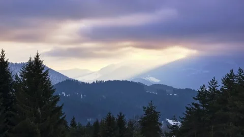 Clouds at sunset over a snowy hilly landscape. Orange coloured clouds, timelapse Stock-Footage 236249781