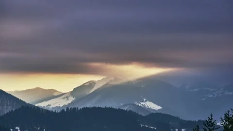 Clouds at sunset over a snowy hilly rural landscape. Orange coloured clouds Stock Footage 236249801