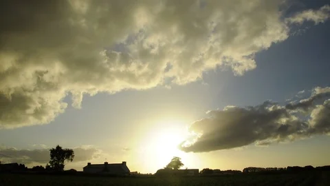 Clouds in sunset running fast over the countryside - timelapse - Farm silhouette Stock Footage 78490619