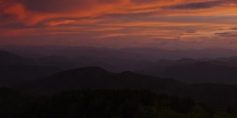 Clouds in the sunset sky over the silhouetted mountain ranges Stock Footage 103401536