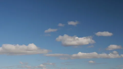 Clouds swiftly swim through the blue sky of the day Stock Footage 128716176