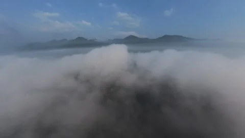 Clouds swirl above mountain peaks, veiling their grandeur Video stock 339857873