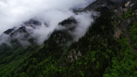 Clouds swirl over mountains during a quiet morning Stock Footage 320303972
