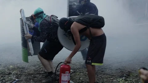 Clouds of tear gas force protestors to retreat during a protest in Stock Footage 124219532