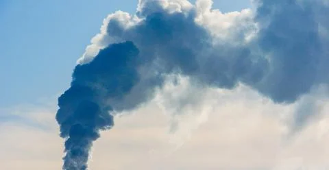 Clouds of thick smoke polluting the air against the sky. Stock Photos