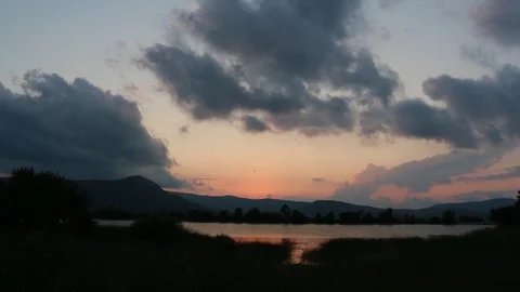 Clouds thickened over the forest lake at sunset Stock Footage 107398355
