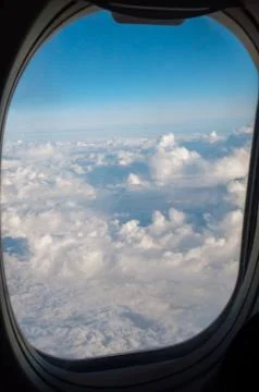 Clouds through the porthole of an airplane Stock Photos