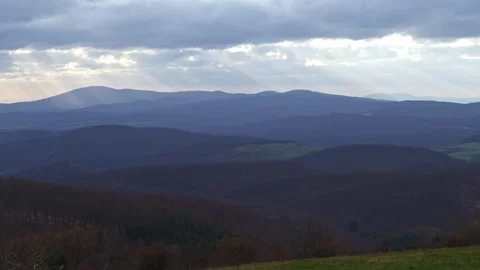 Clouds through which sunlight shines on the hills below 스톡 동영상 271185606