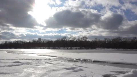 Clouds at time laps over a frozen river Stock Footage 163876341