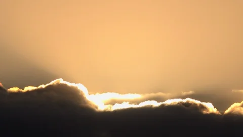 Clouds time lapse with sun shining from behind lifting 4K Stock Footage 129586563