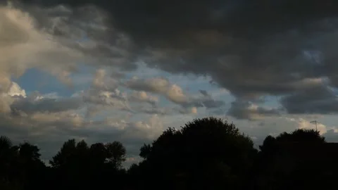 Clouds timelapse over trees and homes silhouettes Stock Footage 315803777