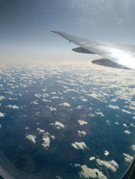 Clouds under the wing of an airplane. Stock Photos